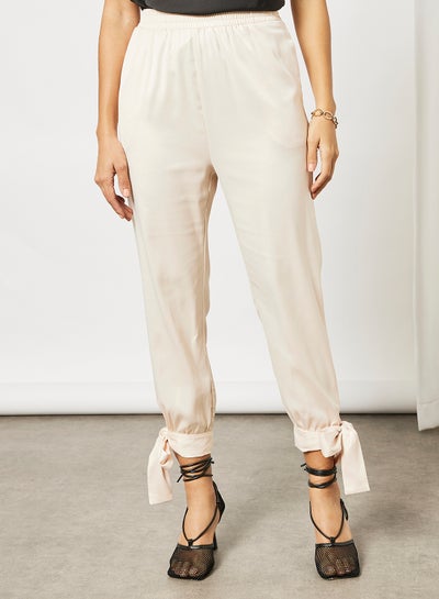 اشتري Solid carrot pants with tie knot details Cream في السعودية